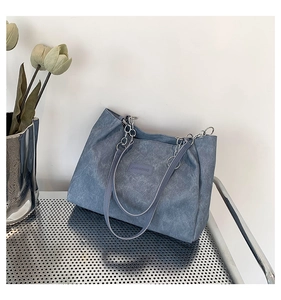 Detail view of blue matte tote bag with JIASHIQING logo and silver chain strap