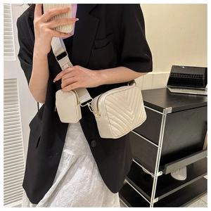 Cream quilted crossbody bag detail with matching mini coin purse and metal hardware