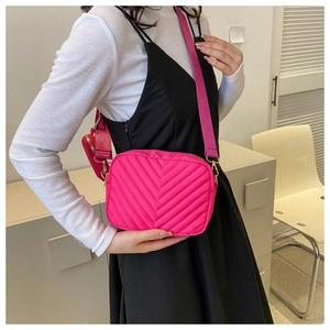 Detailed shot of hot pink quilted crossbody bag with matching strap and coin purse accessory