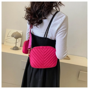 Detailed back view of a pink quilted nylon crossbody bag with matching coin purse charm