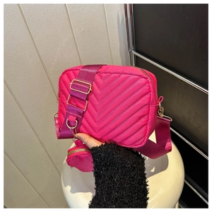 Close-up of rose red quilted crossbody bag with golden hardware and matching coin purse