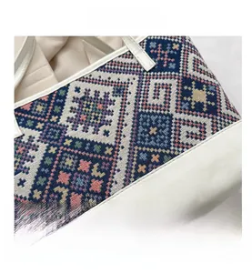 Detail of a large tote bag featuring ethnic geometric woven fabric and cream leather texture