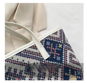Detailed view of bohemian tote bag with colorful ethnic patterns and white leather trim
