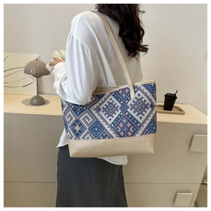 Close-up of geometric jacquard tote bag with ethnic patterns and beige leather straps