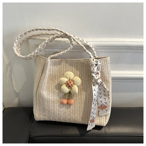 Detail of cream woven tote bag featuring floral accents and a decorative silk scarf