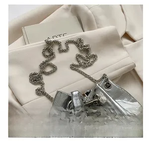 Detailed macro view of silver bucket bag with crocodile texture and metallic chain