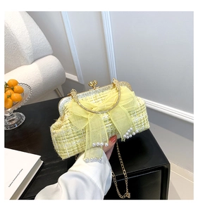 Close-up of yellow tweed handbag with large mesh bow and white pearl embellishments