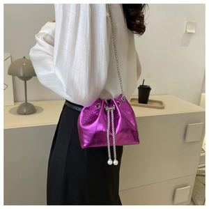 Detail of purple croc-effect mini bucket bag with silver chain and pearl drawstring charm