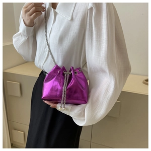 Detail of purple croc-effect bucket bag with chain strap and pearl drawstring charms