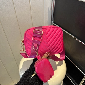 Magenta quilted crossbody bag with adjustable wide strap and a matching mini round coin purse