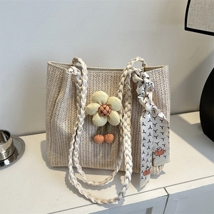 Woven tote bag in cream with sunflower charm and silk scarf detail for beach holidays