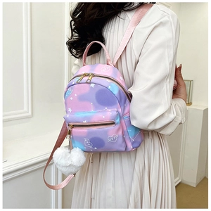 Detailed view of mini gradient backpack with heart patterns and plush ball accessory