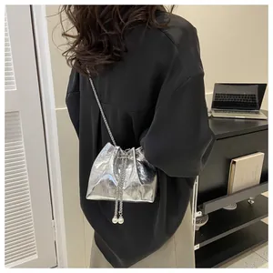 Chic silver mini bucket bag with metallic chain strap and elegant pearl drawstring charms