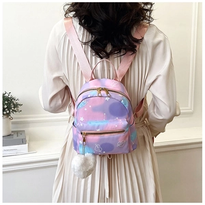 Detailed view of mini gradient pink-purple backpack with white plush ball and heart prints