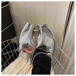 Detail of silver metallic bucket bag with crocodile texture and chain strap