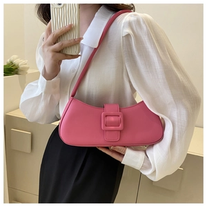 Close-up of a pink leather baguette bag with a stylish matching square buckle detail