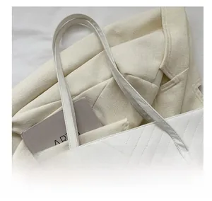 Vista macro della borsa tote in pelle PU bianca con trapuntatura a V e manici piatti