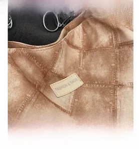 Detail of vintage brown textured fabric tote with a fashion leather patch and silver ring