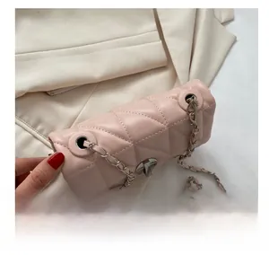 Close-up of pink quilted crossbody bag with silver chain strap and metal lock closure