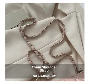 Detail of pink leather woven silver metal chain strap on a trendy crossbody bag