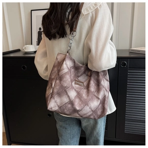 Detail of vintage diamond pattern tote bag with leather logo and chain shoulder strap