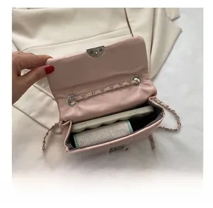 Interior view showing the capacity of this pink quilted crossbody bag with a chain strap