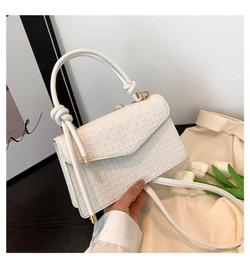 Détail du sac bandoulière blanc matelassé avec dorures et poignée nouée élégante