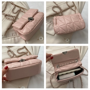 Detail view of pink quilted crossbody bag with silver chain strap and twist lock