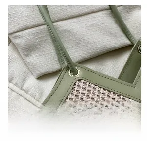 Détail de la texture en paille tressée et bandoulière en cuir vert avec œillets argent