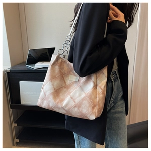 Detail of pink tie-dye checkered tote bag with silver metal chain and leather shoulder strap