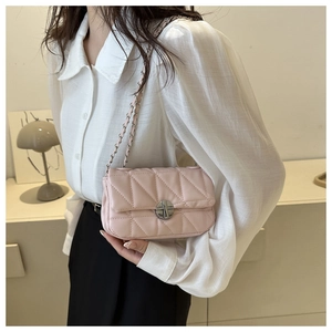 Detail of pink quilted shoulder bag with silver chain strap and metal swivel lock