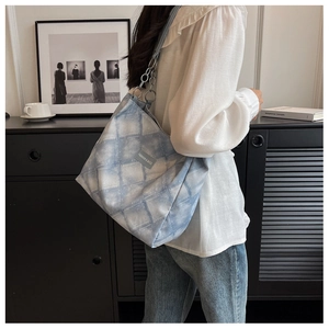 Detail of blue and white geometric canvas tote with chain strap and logo patch
