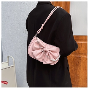 Vue détaillée d'un sac à bandoulière en PU rose avec un gros nœud et chaîne en perles