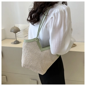 Détail du sac cabas en paille tissée main avec bordure en cuir vert et ouverture en V