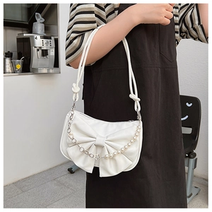 Détail d'un sac à bandoulière blanc à nœud avec chaîne en perles et cuir lisse raffiné
