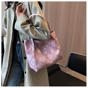 Detail of pink gradient quilted tote bag featuring a leather fashion label and soft texture