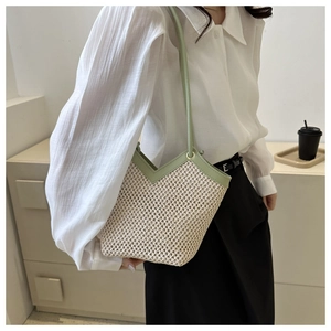 Détail du sac à bandoulière en paille tressée avec bordure en cuir vert clair et haut en V