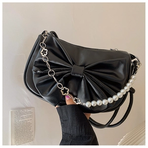 Détail du sac à bandoulière noir avec un grand nœud et une chaîne de perles décorative