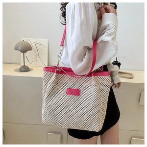 Close-up of woven tote bag with pink leather trim and Fashion & Bag metal logo detail