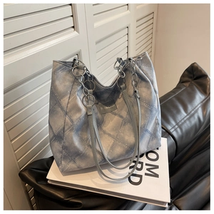 Close-up of blue white checkered tote bag with fashion label and metal chain strap