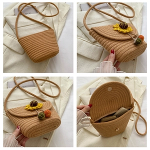 Vue détaillée du sac bandoulière en paille avec fleur de tournesol et pompons colorés