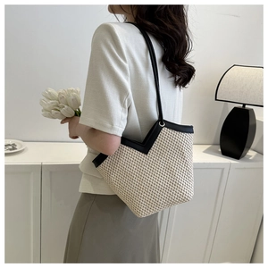 Sac fourre-tout en paille avec bordures noires et style seau minimaliste sur mannequin