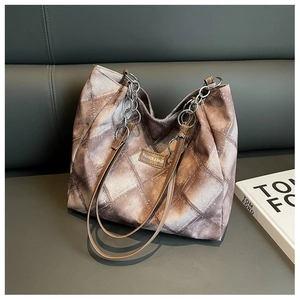 Detail of vintage style tote bag with brown plaid pattern and metal chain leather strap