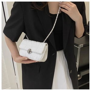 Détail du petit sac blanc matelassé avec chaîne et fermoir rotatif argenté élégant