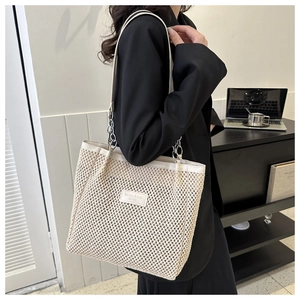 Detail of woven tote bag in cream white with leather chain strap for office commute