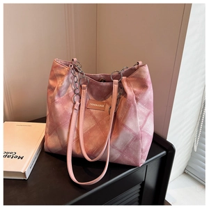 Detail view of pink gradient quilted tote bag with chain strap and magnetic closure