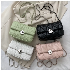 Flat lay of four quilted chain handbags in mint green, black, white, and pink leather