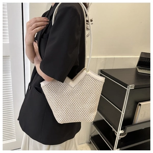 Détail du sac cabas tissé crème avec col en V et texture quadrillée porté par un mannequin