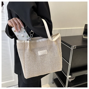 Close-up of beige woven tote bag with leather trim and professional commute styling