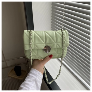 Macro detail of mint green quilted PU leather bag with silver chain strap and metal lock